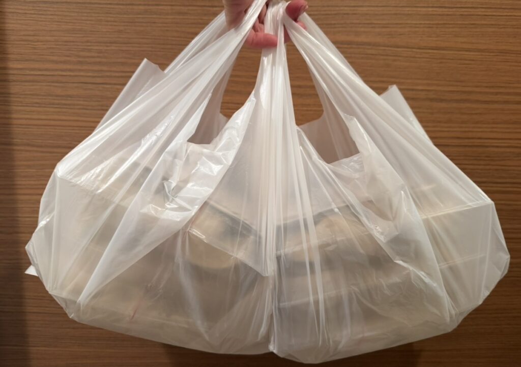 肉汁餃子のダンダダンでテイクアウトした冷凍餃子60個。大量の持ち帰り商品がビニール袋に入っている様子。
