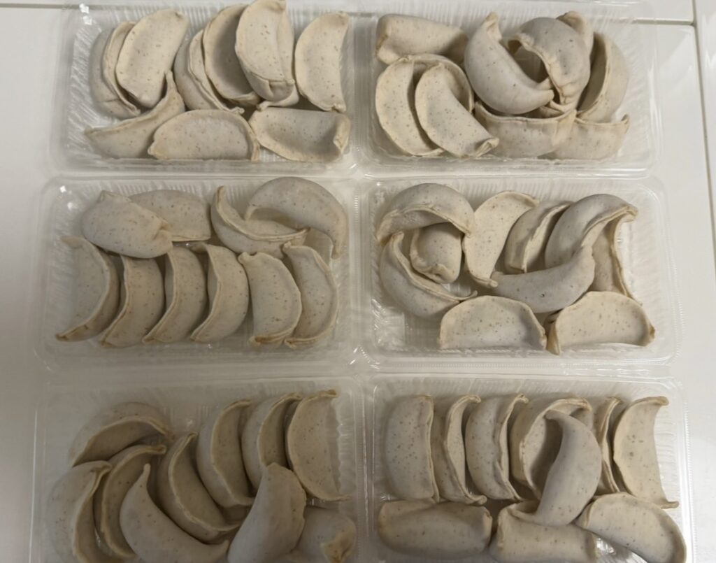 肉汁餃子のダンダダンで購入した冷凍生餃子を並べた様子。大ぶりな餃子が複数のパックに小分けされている。