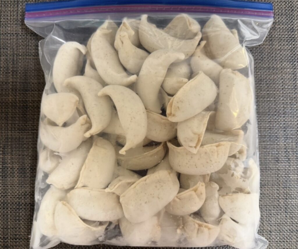 肉汁餃子のダンダダンで購入した冷凍生餃子を、ジップロックにまとめて冷凍保存している様子。大量の餃子が保存袋に入れられている。