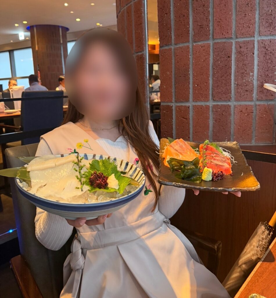 北の味紀行と地酒 北海道 カレッタ汐留店で、いかソーメンとサーモン・紅鮭ルイベ味比べを持つブログ運営者COCO。※顔はぼかしを入れて掲載しています。