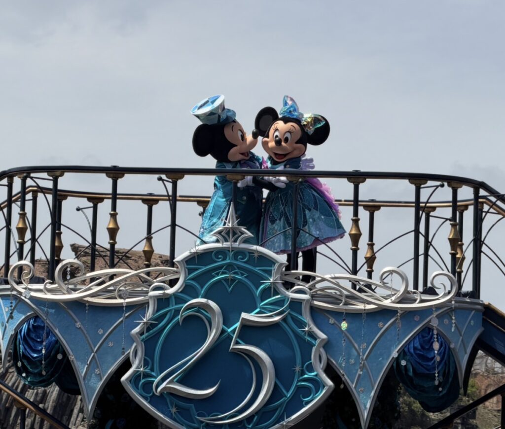 東京ディズニーシー25周年のスペシャルショー「スパークリング・ジュビリー・セレブレーション」で、25周年のロゴの上に立つミッキーマウスとミニーマウスの様子。