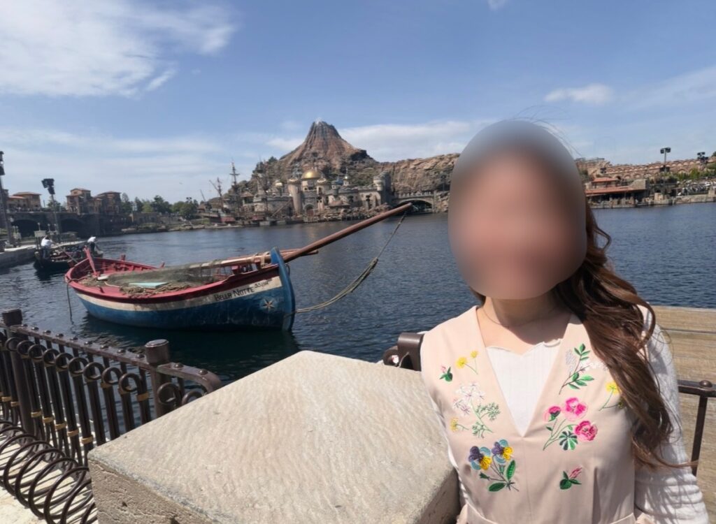 東京ディズニーシーのメディテレーニアンハーバーで、ブログ運営者COCOがショー鑑賞前に場所取りをしている様子。ハーバー越しにプロメテウス火山が見える記念写真。