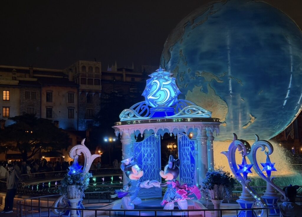 東京ディズニーシー25周年「スパークリング・ジュビリー」の夜景フォトスポット。アクアスフィア前に飾られたミッキーとミニーの25周年オブジェと、幻想的なライトアップを撮影した記念写真。